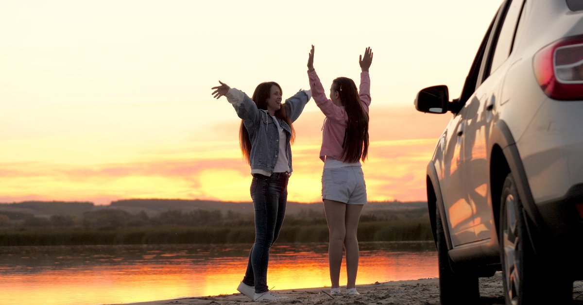 Women taking a break from their roadtrip on the beach